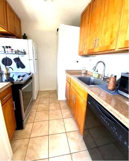 A kitchen with wooden cabinets and black appliances.